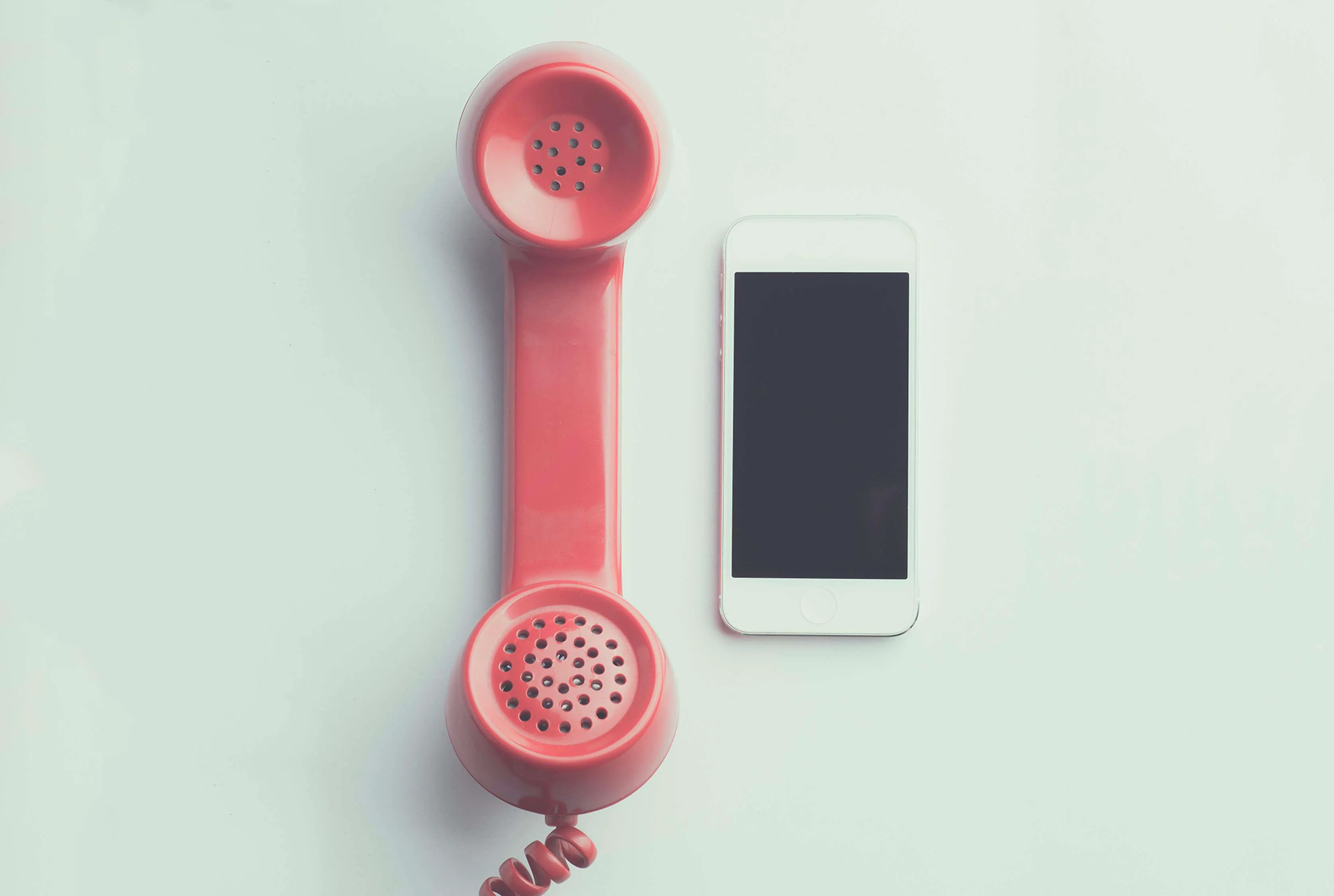 A landline phone next to a cell phone